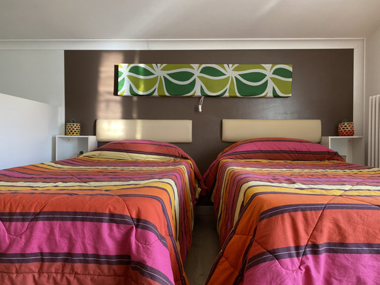 camera con doppio letto singolo con coperte colorate